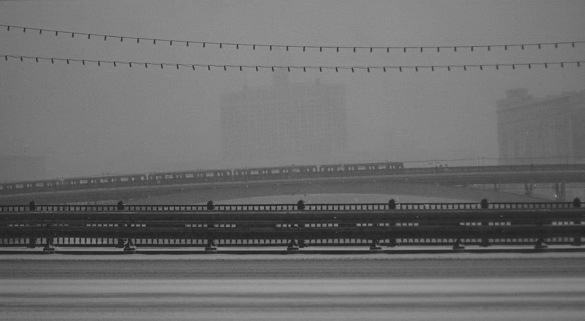 View from Borodinsky Bridge in the center of Moscow towards the Smolensky Metro Bridge and the so-called "White House" (House of the Russian Government) in the background. You can see a metro train traveling between Kievskaya and Smolenskaya stations on the Filevskaya line.